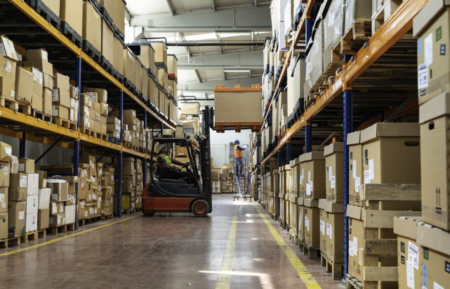 Witness the seamless coordination between the worker, forklift, and stacker loader as the boxes are efficiently arranged for storage or shipment. Embrace the concept of efficiency and optimal use of equipment in this vibrant image, showcasing the essential role of skilled workers in warehouse management